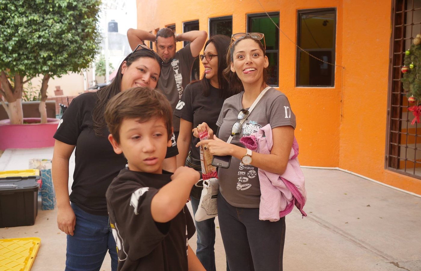 Volunteers and a child gathered in a courtyard during the holiday drive.